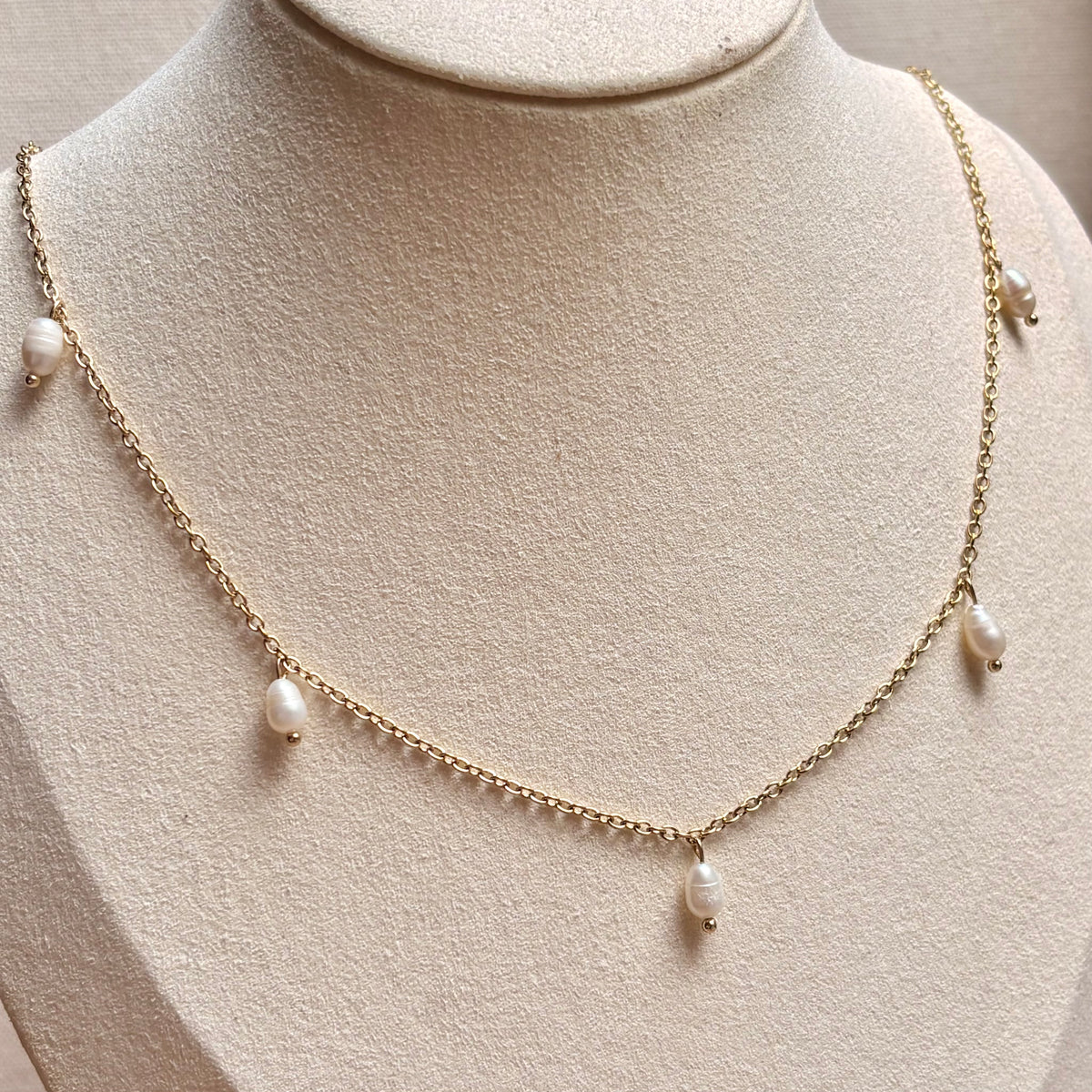 Sprinkle parelketting met vijf zoetwaterparels aan goudkleurige ketting op een buste